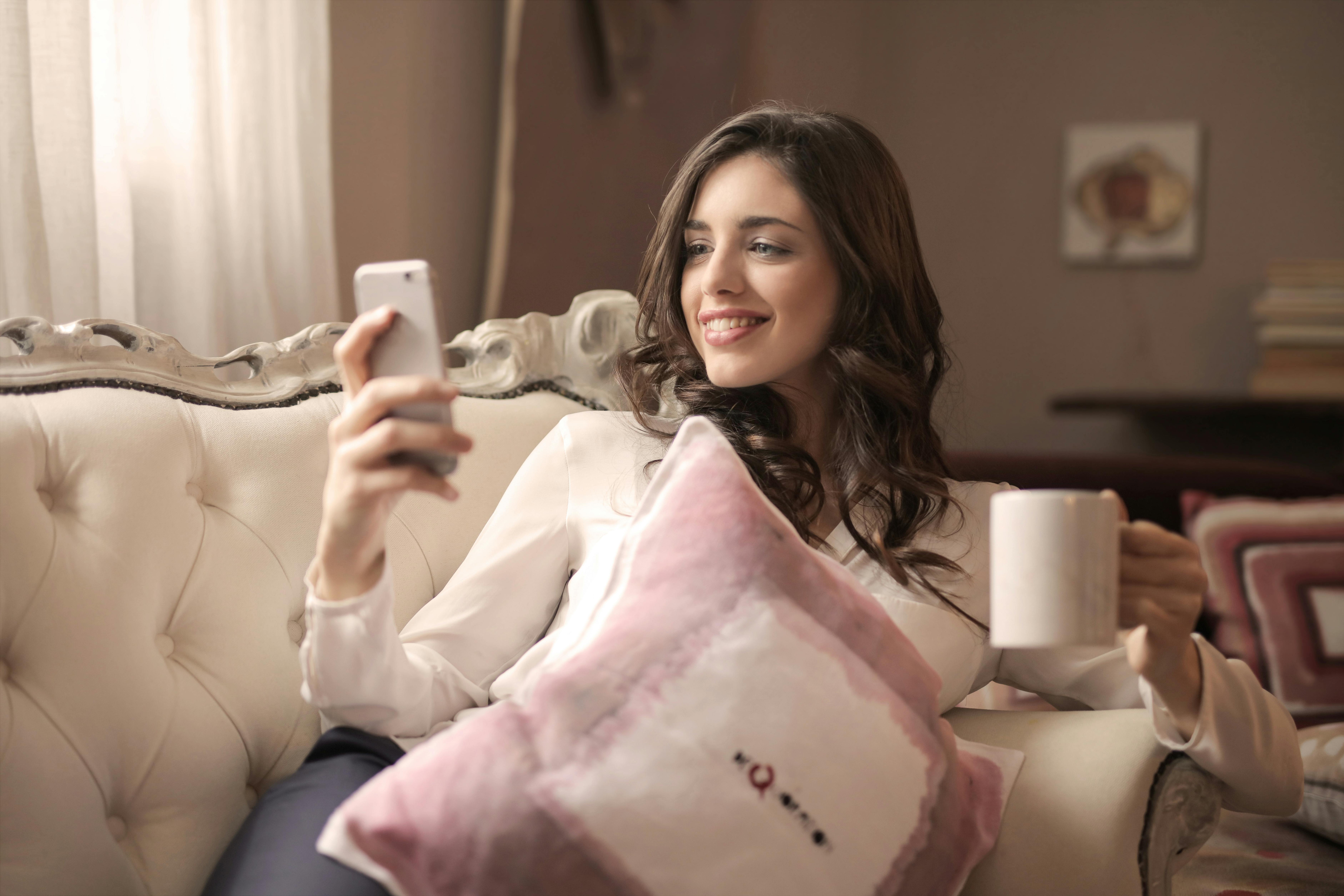 A woman relaxing with coffee while texting the Edem mental wellness companion